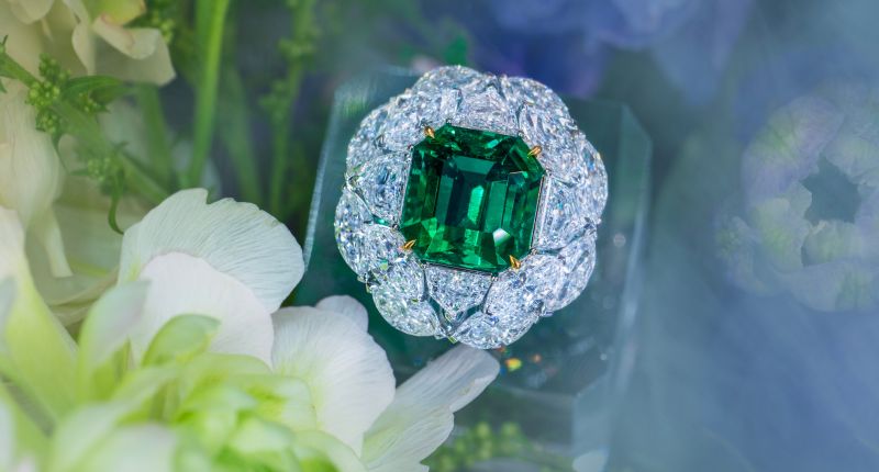 Anillo con una gema central de esmeralda colombiana de 7 quilates, rodeada de diamantes de P.N. Gems, expuesto en Jewellery & Gem Asia Hong Kong.